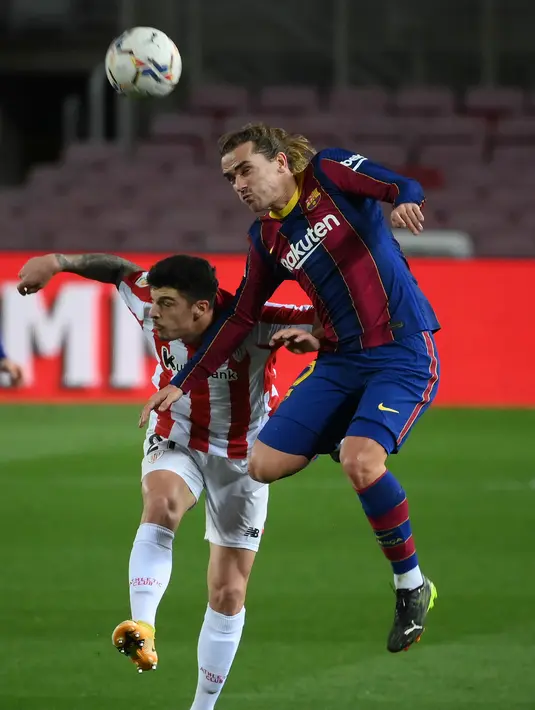 Bek Athletic Bilbao, Ander Capa (kiri) dan gelandang Barcelona, Antoine Griezmann bersaing memperebutkan bola pada pekan ke-21 Liga Spanyol 2020/21 di Stadion Camp Nou, Senin (1/2/2021) dini hari WIB. Barcelona sukses mengalahkan Athletic Bilbao dengan skor tipis 2-1. (LLUIS GENE / AFP)