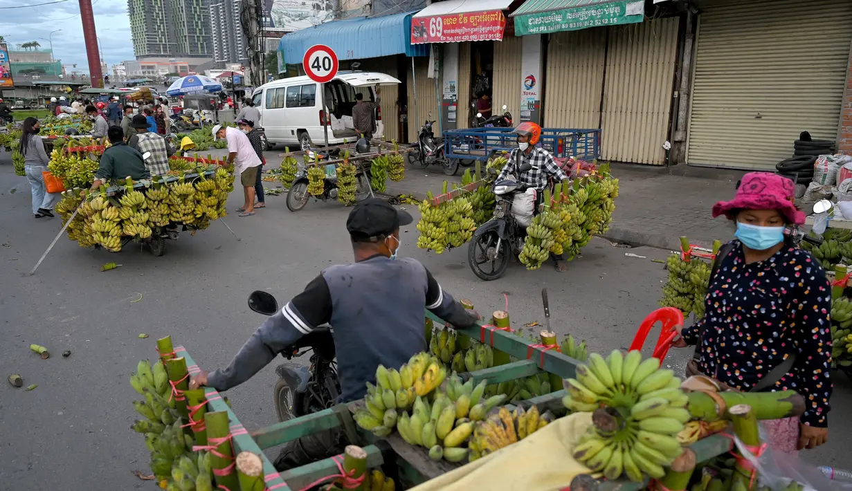 Penjual pisang, menjual buah dari sepeda motor mereka, menunggu pelanggan di sepanjang jalan di Phnom Penh (13/10/2021). Phnom Penh adalah kota terbesar di Kamboja. (AFP/Tang Chhin Sothy)