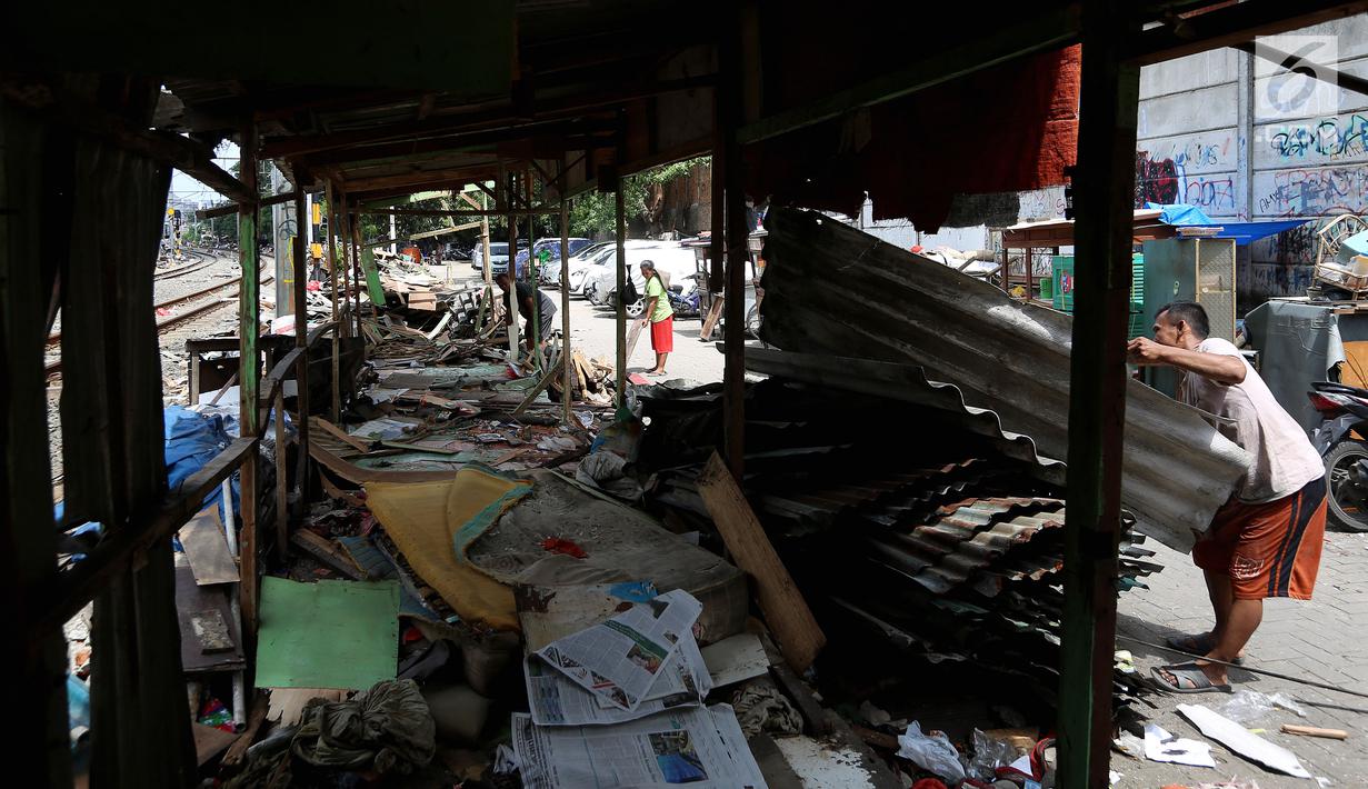 Warga menyelesaikan bongkaran bangunan liar di area Rusun Bendungan Hilir (Benhil) II, Jakarta, Minggu (3/12). Bangunan liar tersebut dibongkar karena berdiri di atas lahan PT Kereta Api Indonesia (PT KAI). (Liputan6.com/JohanTallo)