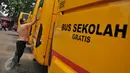 Pekerja membersihkan bus sekolah di Terminal Pasar Minggu, Jakarta, Senin (26/10). Gubernur DKI Basuki Tjahaja Purnama berencana menghapus keberadaan bus sekolah. Sebagai gantinya, pelajar akan digratiskan naik Transjakarta. (Liputan6.com/Gempur M Surya)