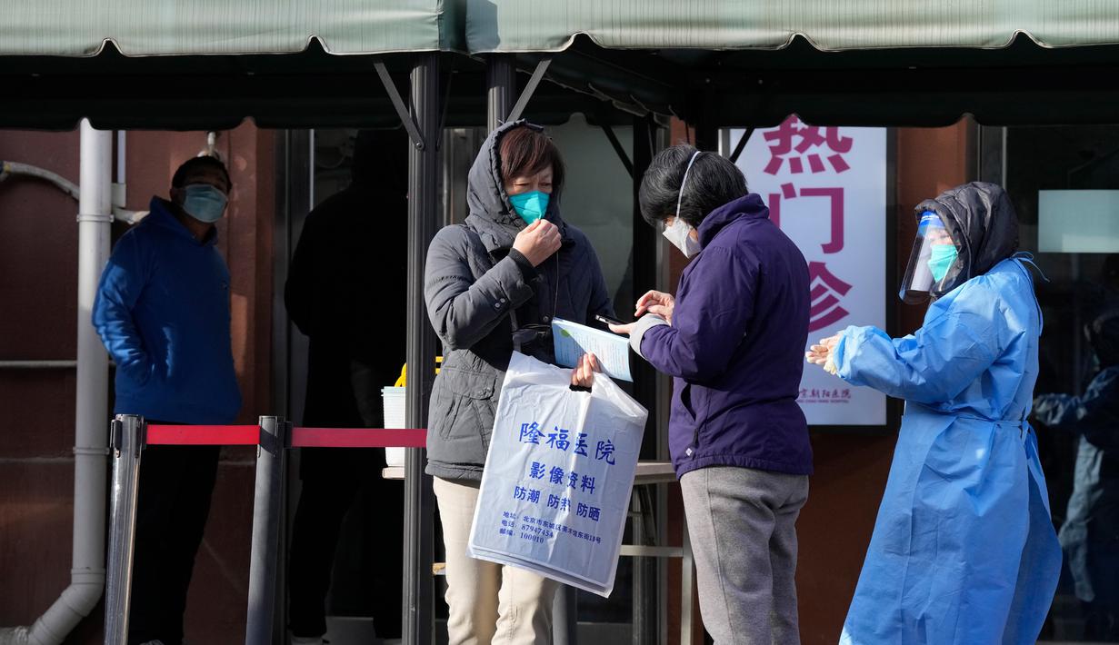 Warga mengobrol di luar klinik di Beijing, China, Kamis (15/12/2022). Seminggu setelah China melonggarkan beberapa tindakan pengendalian COVID-19 yang paling ketat di dunia, ketidakpastian masih ada mengenai arah pandemi di negara dengan jumlah penduduk terpadat di dunia tersebut. (AP Photo/Ng Han Guan)