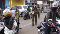 Petugas Satpol PP mengimbau warga untuk menggunakan masker dan menjaga jarak di Pasar Lama, Kota Tangerang, Banten, Sabtu (9/6/2020). Pemkot Tangerang melakukan penegasan pada PSBB tahap dua dengan menugaskan petugas di keramaian guna memutus rantai penyebaran COVID-19.  (Liputan6.com/Angga Yuniar)