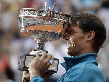 Rafael Nadal mengangkat trofi Prancis Terbuka 2018 setelah mengalahkan petenis Austria, Dominic Thiem pada final di Roland Garros stadium, Paris, (10/6/2018). Nadal menang tiga set 6-4, 6-3, 6-2. (AP/Alessandra Tarantino)
