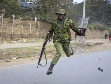 Seorang polisi melompat ketika dia berusaha menghindari granat gas air mata yang dilemparkan kembali ke arah polisi oleh pengunjuk rasa di lingkungan Mathare di Nairobi, Kenya Rabu, 12 Juli 2023. (AP Photo)