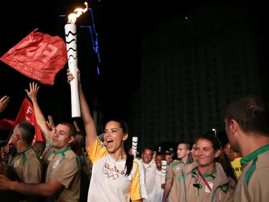 Supermodel Adriana Lima bersorak sambil membawa obor pada malam penyambutan Olimpiade Rio 2016 di Maua Square Rio de Janeiro, Brasil, Kamis (4/8). (REUTERS / Pilar Olivares)