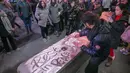 Amir Hussain dari Denmark menggambar menggunakan garam meja untuk memberikan penghormatan kepada mendiang legenda sepak bola Pelé di Times Square di New York pada Kamis, 29 Desember 2022. Sebelum kepergiannya, Pele menjalani perawatan intensif di rumah sakit Albert Einstein, Sao Paulo selama satu bulan terakhir untuk berjuang sembuh dari kanker usus yang dideritanya sejak 2021. (AP Photo/Ted Shaffrey)