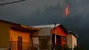 Sebuah helikopter membawa air untuk memadamkan api yang melanda kawasan Dichato Chili, Senin (30/1). Diperkirakan api telah melalap sekitar 680.000 are lahan. (AP Photo / Esteban Felix)