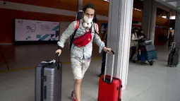 Seorang turis Rusia tiba di Bandara Internasional Bali, Jumat (4/2/2022). Bali kembali dibuka untuk pelancong asing dari semua negara setelah penerbangan internasional dilanjutkan untuk pertama kalinya dalam dua tahun, tapi pengunjung tetap wajib karantina. (AP Photo/Firdia Lisnawati)