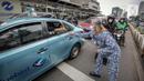 Perserta yang tergabung dalam Forum Kader Bela Negara DKI Jakarta membagikan bunga dan masker kepada pengguna jalan di Jalan Thamrin, Jakarta, Rabu (22/12/2021). Aksi tersebut merupakan bentuk apresiasi terhadap kaum perempuan terutama pada peringatan Hari Ibu. (Liputan6.com/Faizal Fanani)