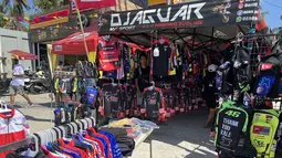 Stand aksesoris balap milik Yogi, pedagang asal Bandung di sekitar Sirkuit Mandalika, Lombok, Sabtu (14/10/2023) menanti para pembeli menjelang berlangsungnya balapan utama ajang MotoGP Mandalika 2023 yang akan digelar Minggu, 15 Oktober 2023. (Bola.com/Benediktus Gerendo Pradigdo)