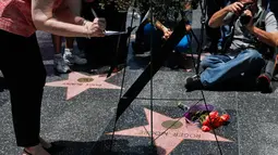 Produser Walk of Fame Ana Martinez menulis sebuah catatan untuk mengenang aktor Inggris, Roger Moore, di Hollywood, Los Angeles, Selasa (23/5). Aktor dikenal karena memerankan James Bond itu meninggal dunia pada usia 89 tahun. (AP Photo/Jae C. Hong)
