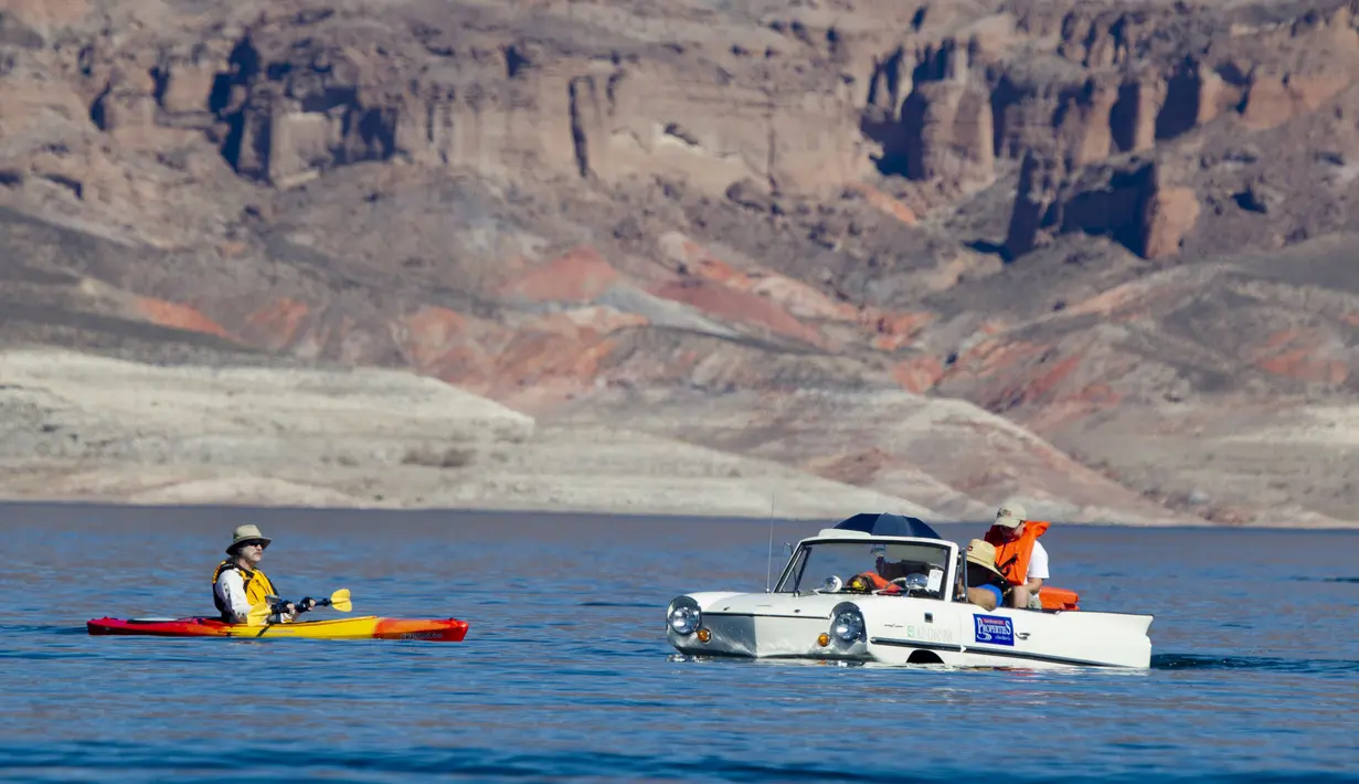 Keluarga Baker menaiki mobil amfibi Amphicar 1965 saat festival Las Vegas Amphicar Swim di Danau Mead, Nevada, Jumat (9/10). (REUTERS/Steve Marcus)