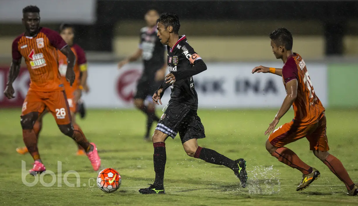 Kapten Bali United FC, Fadil Sausu menggiring bola melewati hadangan para pemain Pusamania Borneo FC pada laga Piala Presiden 2017 di Stadion I Wayan Dipta, Bali, Senin (13/2/2017). (Bola.com/Vitalis Yogi Trisna)