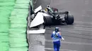 Pembalap Mercedes, Lewis Hamilton menabrak dinding pembatas lintasan saat kualifikasi F1 GP Brasil di sirkuit Interlagos di Sao Paulo, Brasil (11/11). Akibat Hamilton menabrak dinding sesi kualifikasi tertunda sejenak. (AFP Photo/Nelson Almeida)
