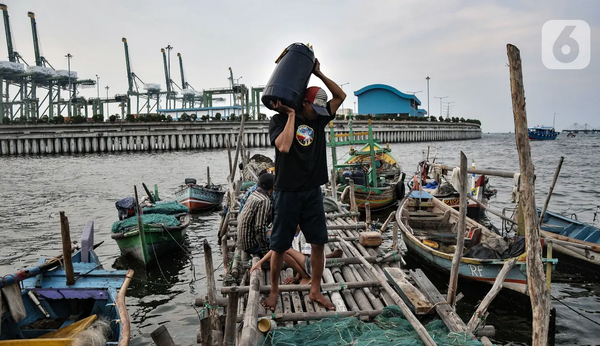 Nelayan membawa wadah berisi ikan di kawasan pesisir Kalibaru, Cilincing, Jakarta Utara, Senin (19/9/2022). Kenaikan BBM bersubsidi jenis solar meyebabkan biaya operasional untuk melaut membengkak, sementara hasil tangkapan dan harga jual ikan saat ini tengah merosot. (merdeka.com/Iqbal S. Nugroho)