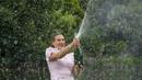 Aryna Sabalenka dari Belarusia menyemprotkan sampanye di Royal Botanical Gardens setelah mengalahkan Elena Rybakina dari Kazakhstan pada final tunggal putri kejuaraan tenis Australia Open 2023 di Melbourne, Minggu (29/1/2023). Kemenangan ke-11 berturut-turut tahun ini juga membawa Sabalenka kembali ke peringkat kedua WTA di belakang Iga Swiatek dari Polandia. (AP Photo/Dita Alangkara)