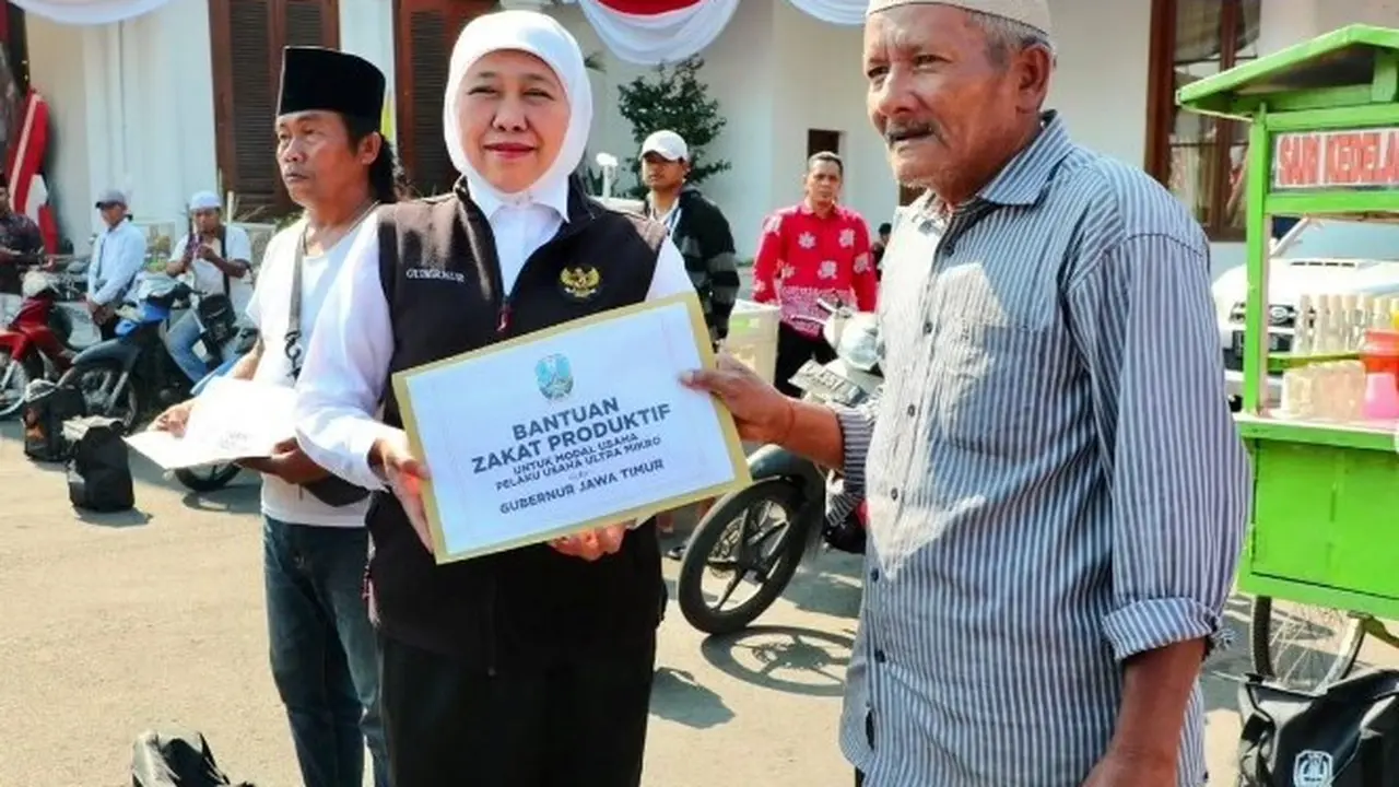 Khofifah membagikan paket sembako dan bantuan uang zakat kepada PKL di sekitar Gedung Grahadi. (Istimewa)