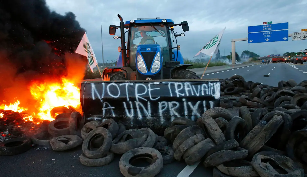 Para petani Perancis memblokir salah satu ruas jalan utama di Seclin, Perancis, Rabu (22/7/2015). Petani Perancis memprotes karena belum mendapatkan keuntungan dari kenaikan harga daging dan susu yang dijual di pasaran. (REUTERS/Pascal Rossignol)