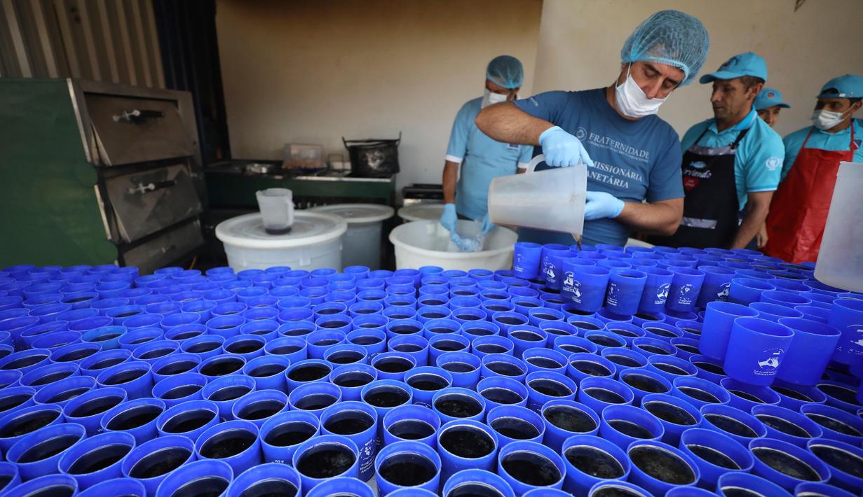 Relawan menyiapkan minuman untuk dihidangkan kepada pengungsi Venezuela di tempat penampungan Divina Providencia, La Parada, Cucuta, Kolombia, Senin (18/2). Tempat penampungan ini menyiapkan makanan kecuali hari Minggu. (AP Photo/Fernando Vergara)