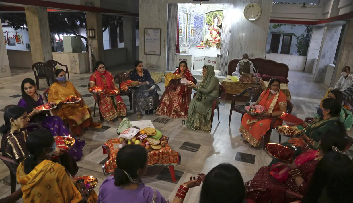 Wanita Hindu melakukan ritual sebelum berbuka puasa sepanjang hari selama festival 'Karwa Chauth', di Jammu, India (4/11/2020). Wanita Hindu yang menikah berpuasa dan berdoa ke bulan untuk kesejahteraan, kemakmuran, dan umur panjang suami mereka di festival ini. (AP Photo/Channi Anand)