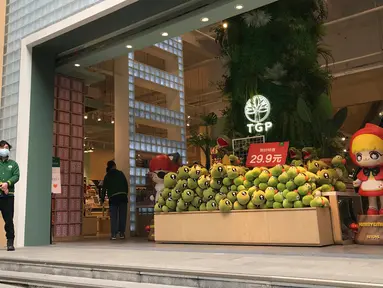 Penjaga toko menunggu pelanggan di sebuah jalan ritel di Wuhan di provinsi Hubei, China tengah (30/3/2020). Para pemilik toko di kota yang menjadi pusat wabah virus corona (Covid-19) itu mulai buka kembali usahanya pada Senin, tapi para pelanggannya masih tampak sepi. (AP Photo/Olivia Zhang)