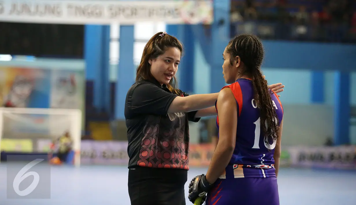 Wasit Ornpimol Kittiteerasopon (kiri) memperingati pemain Papua Desi laga final hoki putri PON XIX Jabar antara DKI Jakarta melawan Papua di Gymnasium UPI, Bandung, Senin (19/9). DKI Jakarta unggul 4-2 atas Papua. (Liputan6.com/Helmi Fithriansyah)