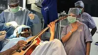 Abhishek Prasad (37) menjalani operasi otak sambil bermain gitar. Cara ini dinilai membantu dalam proses penyembuhan (AFP)