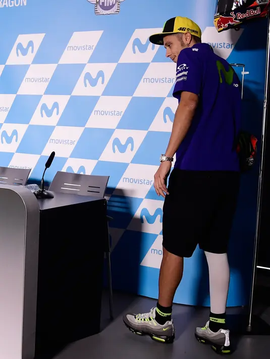 Pembalap tim Yamaha, Valentino Rossi berjalan pincang menuju tempat konferensi pers MotoGP Aragon 2017 di Sirkuit MotorLand, Spanyol, Kamis (21/9). Rossi dinyatakan lolos tes medis untuk tampil di MotoGP Aragon akhir pekan ini. (JAVIER SORIANO/AFP)