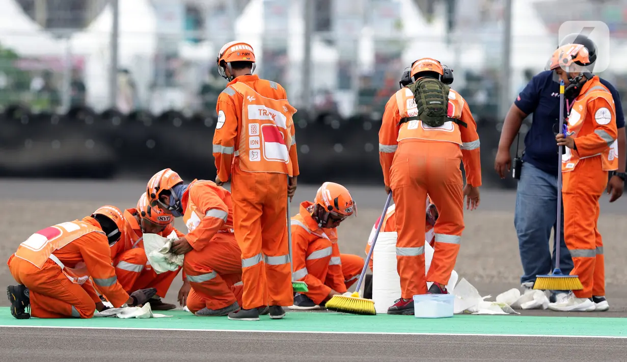 Marshal membersihkan lintasan jelang kualifikasi MotoGP di Pertamina Mandalika International Street Sirkuit, Lombok, Sabtu (19/3/2022). Tak hanya membantu pembalap, marshal juga bertugas membersihkan lintasan usai insiden agar kembali bisa digunakan. (Liputan6.com/Helmi Fithriansyah)