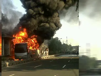 Sebuah bus Transjakarta terbakar di kawasan Salemba, Jakarta Pusat, Jumat (3/7/2015). Kobaran api tampak membakar bus gandeng berwarna abu-abu itu, bahkan api juga menyambar bagian halte. (twitter.com/FaisalRizalical)