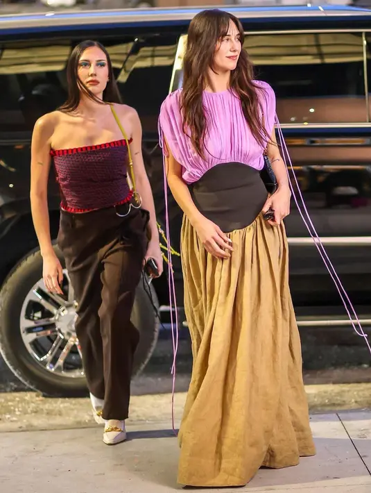 Devon Lee Carlson memakai dress Silk Chiffon Linen Burlap, Lila Knee Boot, dan Kira Geometric Sunglasses