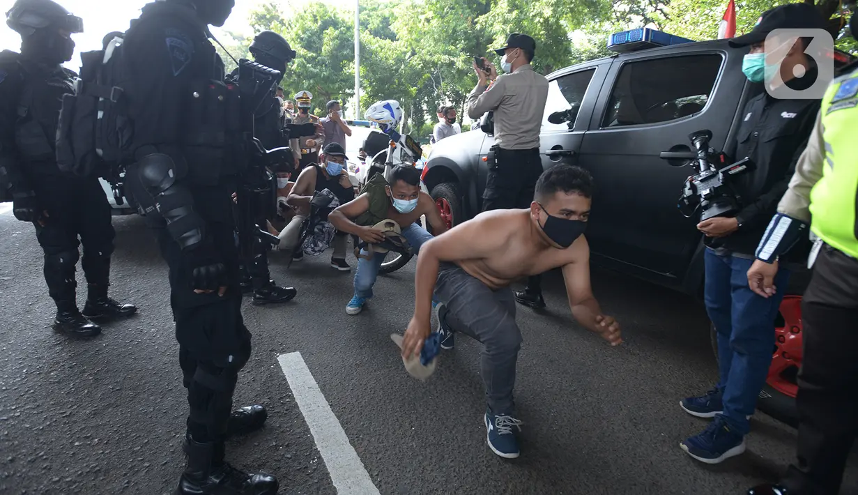 Sejumlah orang berjalan jongkok setelah diamankan petugas kepolisian di Kawasan Senayan, Jakarta, Kamis (8/10/2020). Mereka diduga hendak melakukan unjuk rasa di depan gedung DPR. (merdeka.com/Imam Buhori)