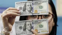 Teller menunjukan mata uang dolar AS di penukaran mata uang, Jakarta, Kamis (13/4). Nilai tukar rupiah terpantau menguat 0,09% atau 12 poin ke Rp13.263 per dolar AS di pasar spot. (Liputan6.com/Angga Yuniar)