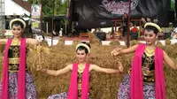 3 penari dengan latar orang-orangan sawah di depan Panggung Festival Ujungan, Banjarnegara. (Liputan6.com/Dimas untuk Muhamad Ridlo)