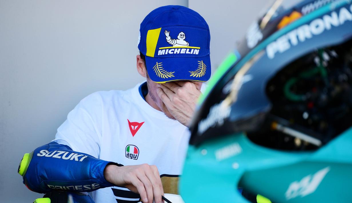 Pembalap Suzuki Esctar, Joan Mir, mengusap air mata kebahagiaan usai balapan MotoGP Valencia di Sirkuit Ricardo Tormo, Minggu (15/11/2020). Meski finis ketujuh, Joan Mir berhasil mengunci gelar juara dunia MotoGP 2020. (AFP/Lluis Gene)