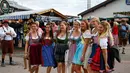 Sejumlah wanita berpose memakai pakaian tradisional Bavaria saat 182th Oktoberfest di Munich, Jerman (19/9/2015). Jutaan peminum bir akan datang ke ibukota Bavaria selama dua minggu untuk 182th Oktoberfest. (REUTERS/Michael Dalder)