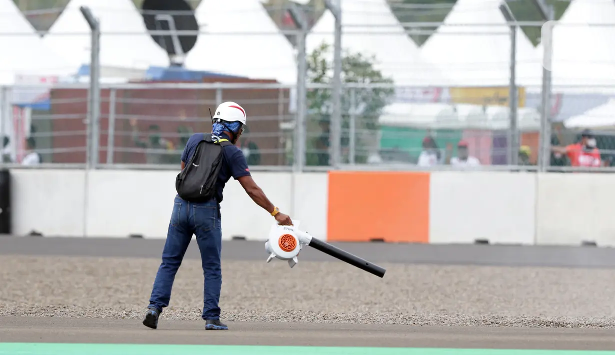 Marshal membersihkan lintasan jelang kualifikasi MotoGP di Pertamina Mandalika International Street Sirkuit, Lombok, Sabtu (19/3/2022). Paddock Marshals memastikan semua motor berada dengan benar di area perakitan, sebelum mereka menuju ke grid. (Liputan6.com/Helmi Fithriansyah)