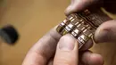 Pekerja Comite Franceclat menyelesaikan pembuatan gelang emas 'Dunes' yang dibuat dengan mesin cetak 3D di Besancon, Prancis timur, 11 Oktober 2017. Mesin cetak 3D kini mulai merambah ke dunia desain perhiasan. (AFP FOTO / SEBASTIEN BOZON)