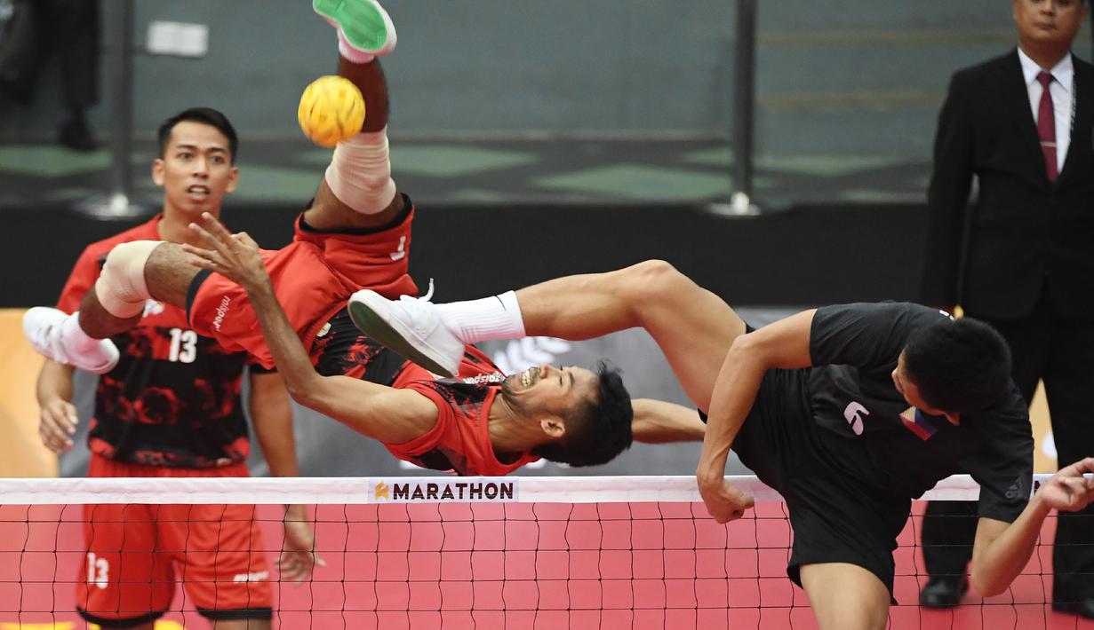 Gaya atlet Indonesia, Syaiful Rijal melakukan smash ke arah pemain Filipina, Regie Reznan Fabriga pada ajang Sepak Takraw SEA Games 2017 di Kuala Lumpur, (21/8/2017). (AFP/Adek Berry)