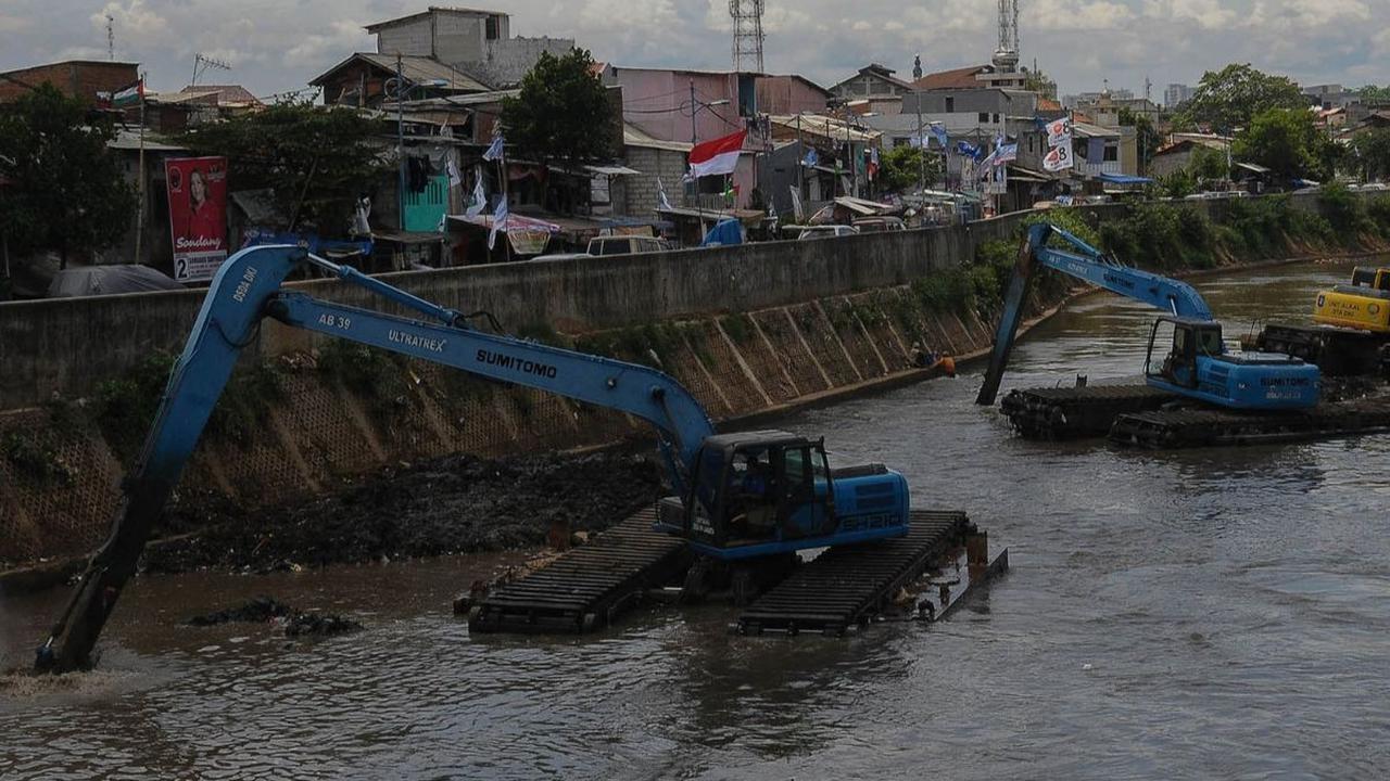 Pekerja menggunakan ekskavator untuk mengeruk material lumpur yang mengendap di Kali Ciliwung, Jakarta, Selasa (16/1/2023). Ancaman banjir masih terus membayangi Ibu Kota Jakarta, terlebih ketika musim penghujan tiba.