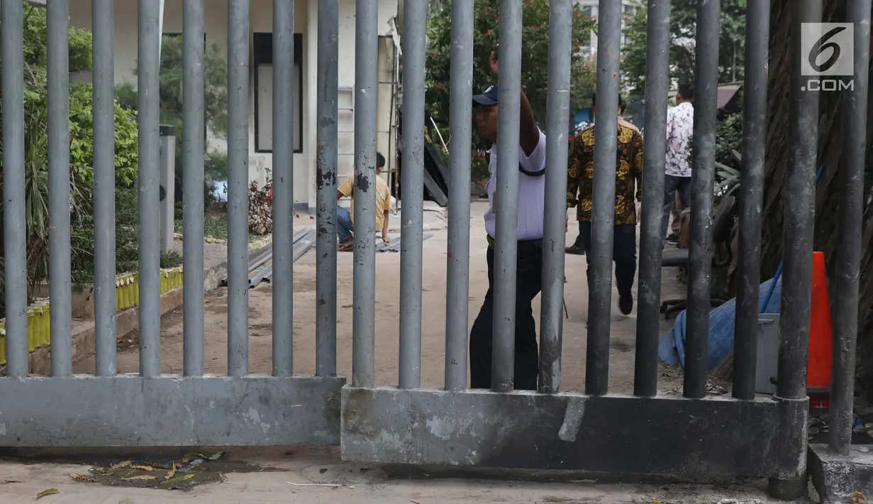 Petugas berjaga di pintu masuk samping gedung Bawaslu yang sempat terbakar saat terjadi kericuhan massa aksi di perempatan Jalan MH Thamrin, Jakarta, Kamis (23/5/2019). Sebelumnya, aksi unjuk rasa yang dilakukan massa pada Rabu (23/5) berakhir ricuh. (Liputan6.com/Helmi Fithriansyah)