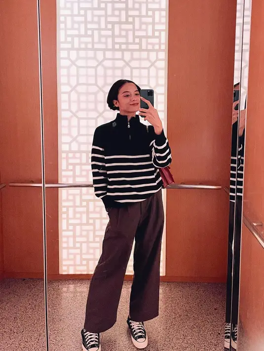 Ia memasangkan sweater tersebut dengan loose pants coklat dan sneakers. [@putrimarino]