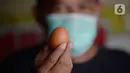 Pedagang memperlihatkan telur ayam lokal dagangannya di pinggir jalan Pamulang Permai, Tangerang Selatan, Banten, Jumat (30/10/2020). Memasuki libur panjang pada pekan ini, harga telur dipasaran yang sebelumnya mencapai 23 ribu kini turun menjadi Rp 21 ribu per kilogram. (merdeka.com/Dwi Narwoko)