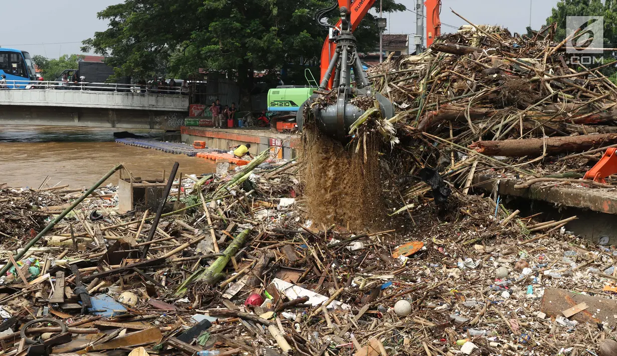 Alat berat mengangkat sampah yang menumpuk di Pintu Air Manggarai, Jakarta, Jumat (26/4). Sampah yang didominasi potongan bambu dan botol plastik kembali memenuhi Pintu Air Manggarai akibat curah hujan yang tinggi di kawasan Bogor dan sekitarnya, Kamis (25/4). (Liputan6.com/Helmi Fithriansyah)