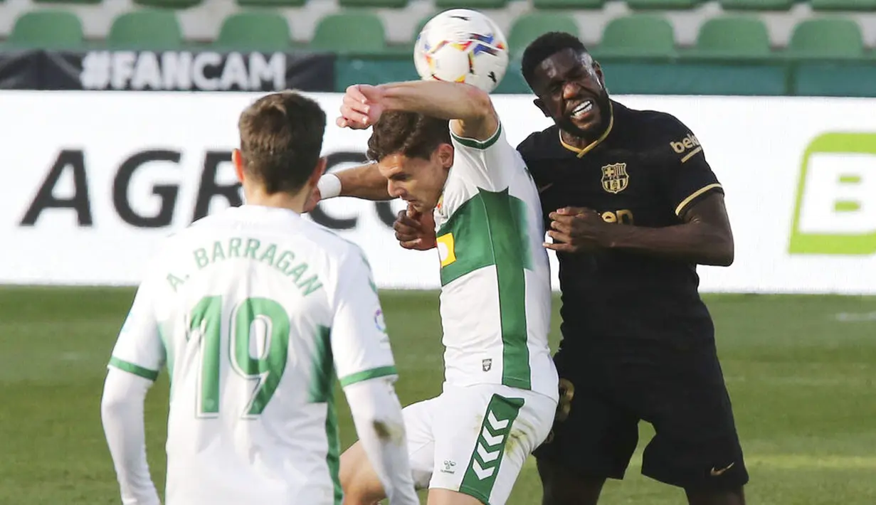 Bek Barcelona, Samuel Umtiti, duel udara dengan pemain Elche, Lucas Boye, pada laga Liga Spanyol di Stadion Manuel Martinez Valero, Minggu (24/1/2021). Barcelona menang dengan skor 2-0. (AP/Alberto Saiz)