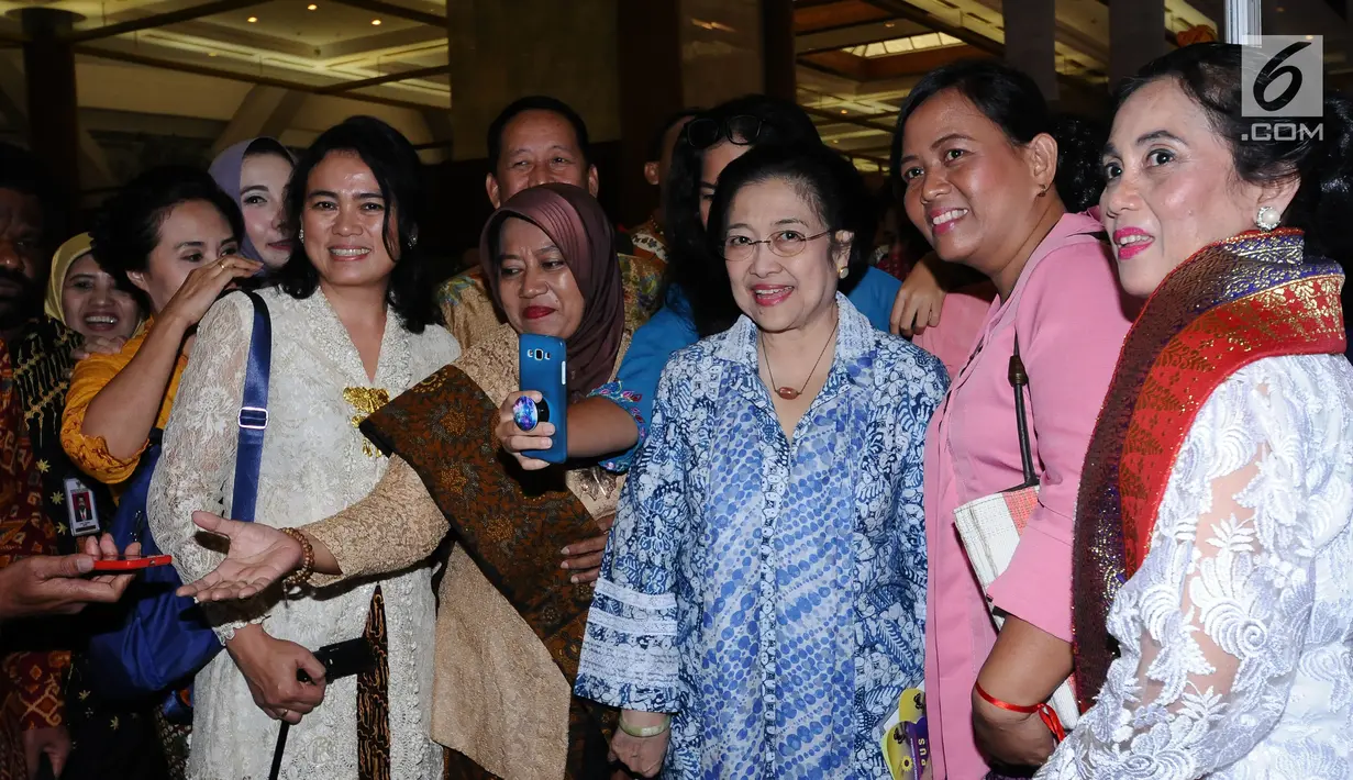 Presiden kelima RI Megawati Soekarnoputri (batik biru) melayani permintaan foto bersama peserta Festival Prestasi Indonesia di JCC Jakarta, Senin (21/8). Festival dibuka oleh Menko Kemaritiman Luhut B Pandjaitan. (Liputan6.com/Helmi Fithriansyah)