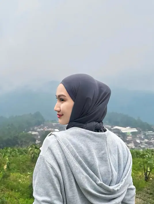 Melody mengenakan kerudung abu-abu. Wajahnya dipulas flawless fresh mengaplikasikan lipstik merahnya. [@melodylaksani92]