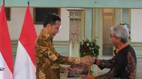 Wakil Menteri Luar Negeri, Dr. A.M. Fachir menyerahkan secara simbolis buku “Dasawarsa Diplomasi Batik Indonesia” kepada Presiden Joko Widodo.