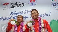 Dua atlet angkat besi Indonesia, Sri Wahyuni Agustiani dan Eko Yuli Irawan menunjukkan medali perak di Terminal 2 di Bandara Soetta, Minggu (14/08). Pemerintah menjanjikan bonus sebesar Rp 2 miliar untuk peraih medali perak. (Liputan6.com/Helmi Afandi)