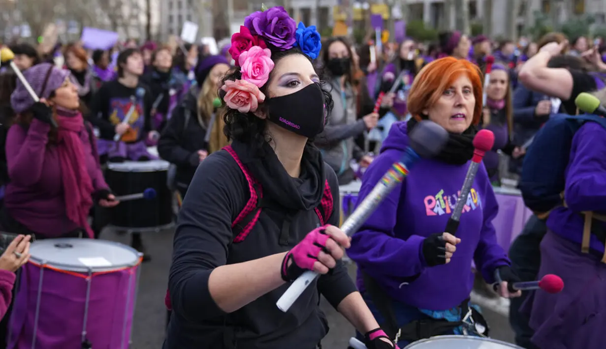 Perempuan menabuh genderang saat pawai pada Hari Perempuan Internasional di Madrid, Spanyol, 8 Maret 2022. Ribuan perempuan berbaris di Madrid dan kota-kota Spanyol lainnya sebagai bagian dari Hari Perempuan Internasional. (AP Photo/Paul White)